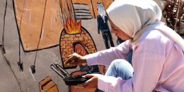 في غزة .. جنة ترسم الأمل على جدار منزلها المدمر